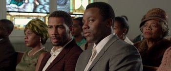 Movie still from “Sparkle” (2012), directed by Salim Akil – A couple of men standing next to each other in a room; Close Up shot, Over the shoulder angle