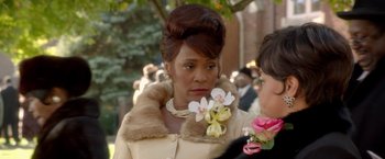 Movie still from “Sparkle” (2012), directed by Salim Akil – A woman in a fur coat holding a bouquet of flowers in her hand; Close Up shot, Over the shoulder angle