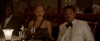 A man and a woman sitting at a table with a glass of wine in front of them