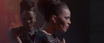 Movie still from “Sparkle” (2012), directed by Salim Akil – A woman in a black dress with a braid in her hair; Close Up shot, Over the shoulder angle