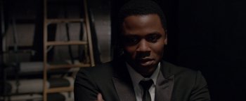 Movie still from “Sparkle” (2012), directed by Salim Akil – A man wearing a suit and tie in front of a ladder; Close Up shot, High angle