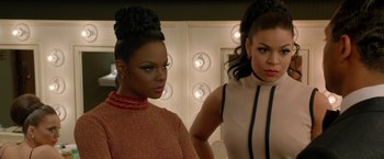 Two women standing next to each other in front of a mirror