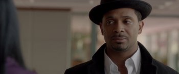 Movie still from “Sparkle” (2012), directed by Salim Akil – A person wearing a hat and a suit; Close Up shot, Over the shoulder angle