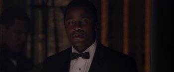 Movie still from “Sparkle” (2012), directed by Salim Akil – A man in a suit and a bow tie; Close Up shot, Over the shoulder angle