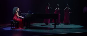 Movie still from “Sparkle” (2012), directed by Salim Akil – A couple of women singing into microphones on a stage; Extreme Wide shot, High angle