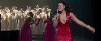 Movie still from “Sparkle” (2012), directed by Salim Akil – A woman in a red dress singing into a microphone; Medium shot, High angle