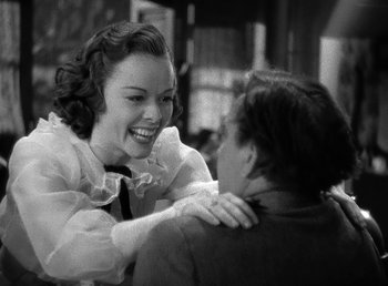 Movie still from “Spawn of the North” (1938), directed by Henry Hathaway – A woman in a white blouse and a man in a black tie; Medium shot, Over the shoulder angle