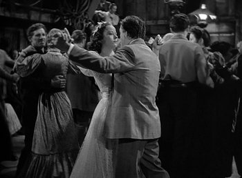 Movie still from “Spawn of the North” (1938), directed by Henry Hathaway – A man and a woman dancing in front of a group of people; Wide shot, Low angle