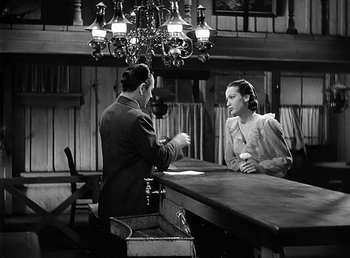 Movie still from “Spawn of the North” (1938), directed by Henry Hathaway – A man and a woman sitting at a table; Wide shot, High angle