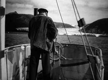 Movie still from “Spawn of the North” (1938), directed by Henry Hathaway – A man standing on the deck of a boat in the water; Medium shot, High angle
