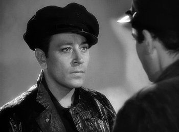 Movie still from “Spawn of the North” (1938), directed by Henry Hathaway – A black and white photo of a man wearing a hat; Close Up shot, Over the shoulder angle