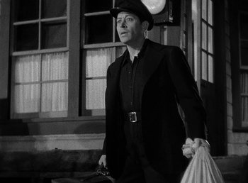 Movie still from “Spawn of the North” (1938), directed by Henry Hathaway – A black and white photo of a man in a suit and hat; Medium shot, Low angle