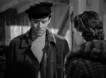 Movie still from “Spawn of the North” (1938), directed by Henry Hathaway – A man wearing a hat and a jacket talking to a woman; Medium shot, Over the shoulder angle