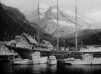 Movie still from “Spawn of the North” (1938), directed by Henry Hathaway – A black - and - white photo of boats docked in a harbor; Extreme Wide shot, Low angle