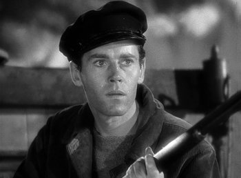 Movie still from “Spawn of the North” (1938), directed by Henry Hathaway – Black and white photograph of a man in a hat holding a rifle; Close Up shot, Low angle
