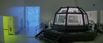 Movie still from “Species” (1995), directed by Roger Donaldson – A person standing on a flight of stairs next to an elevator; Extreme Wide shot, High angle