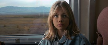 Movie still from “Species” (1995), directed by Roger Donaldson – A woman sitting in front of a window; Close Up shot, Over the shoulder angle