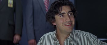 Movie still from “Species” (1995), directed by Roger Donaldson – A person with a beard smiling; Close Up shot, Low angle