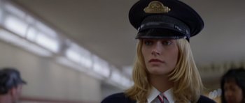 Movie still from “Species” (1995), directed by Roger Donaldson – A woman in a uniform is looking at the camera; Close Up shot, Low angle