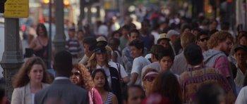 Movie still from “Species” (1995), directed by Roger Donaldson – A crowd of people walking down a street; Wide shot, High angle