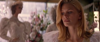 Movie still from “Species” (1995), directed by Roger Donaldson – A woman with long blonde hair wearing a white dress; Close Up shot, Over the shoulder angle