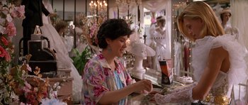 Movie still from “Species” (1995), directed by Roger Donaldson – A woman sitting at a table in front of a mirror; Medium shot, Over the shoulder angle