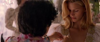 Movie still from “Species” (1995), directed by Roger Donaldson – A woman in a white dress is putting a ring on her finger; Close Up shot, Over the shoulder angle