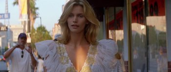 Movie still from “Species” (1995), directed by Roger Donaldson – A woman with long blonde hair wearing a white dress; Close Up shot, Low angle