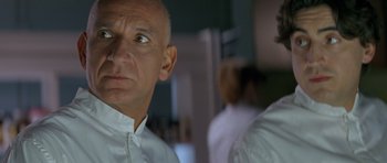 Movie still from “Species” (1995), directed by Roger Donaldson – A man in a white shirt looking at another man in a white shirt; Close Up shot, Low angle