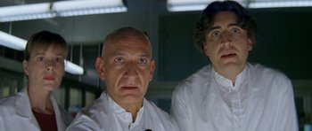 Movie still from “Species” (1995), directed by Roger Donaldson – A man and a woman wearing white shirts and looking at the camera; Close Up shot, Low angle
