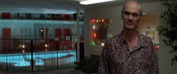 Movie still from “Species” (1995), directed by Roger Donaldson – A man standing in front of an indoor swimming pool; Medium shot, Low angle