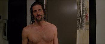 Movie still from “Species” (1995), directed by Roger Donaldson – A man with long hair and a beard is posing for the camera; Close Up shot, Over the shoulder angle