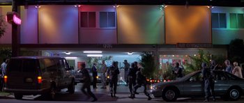 Movie still from “Species” (1995), directed by Roger Donaldson – A group of people walking in front of a building at night; Extreme Wide shot, Low angle