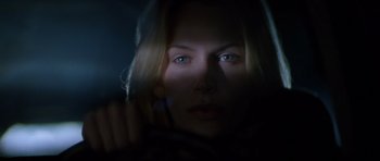 Movie still from “Species” (1995), directed by Roger Donaldson – A beautiful woman with blue eyes looking at the camera; Close Up shot, Low angle