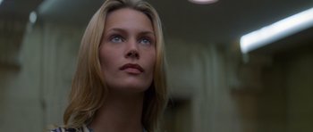 Movie still from “Species” (1995), directed by Roger Donaldson – A beautiful woman with long blonde hair and blue eyes; Close Up shot, Low angle