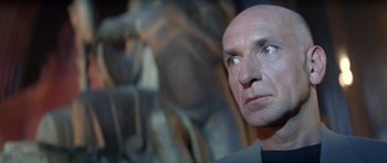 Movie still from “Species” (1995), directed by Roger Donaldson – A man with bald head looking into the distance; Close Up shot, Low angle