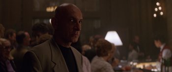 Movie still from “Species” (1995), directed by Roger Donaldson – A man with a bald head is looking into the distance; Close Up shot, Low angle