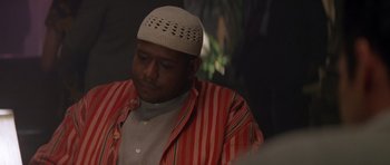 Movie still from “Species” (1995), directed by Roger Donaldson – A man wearing a white hat and a striped shirt; Close Up shot, Over the shoulder angle