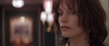 Movie still from “Species” (1995), directed by Roger Donaldson – A woman's face in a dark room; Close Up shot, Over the shoulder angle