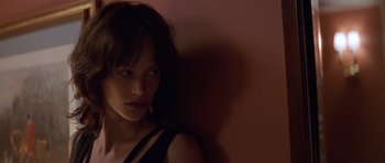 Movie still from “Species” (1995), directed by Roger Donaldson – A beautiful woman leaning up against a pink wall; Close Up shot, High angle