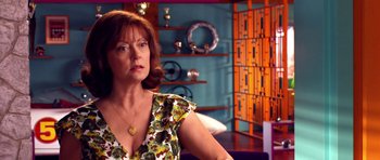 Movie still from “Speed Racer” (2008), directed by Lilly Wachowski – A woman in a green dress is sitting in a room; Close Up shot, Over the shoulder angle