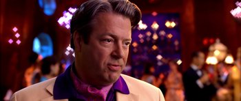 Movie still from “Speed Racer” (2008), directed by Lilly Wachowski – A person wearing a suit and tie; Close Up shot, Over the shoulder angle