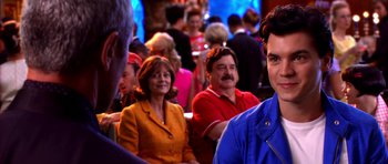 Movie still from “Speed Racer” (2008), directed by Lilly Wachowski – A group of people sitting in a room; Close Up shot, Over the shoulder angle