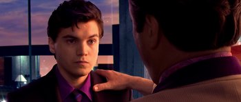 Movie still from “Speed Racer” (2008), directed by Lilly Wachowski – A young man in a purple shirt is looking at his reflection in a mirror; Close Up shot, Over the shoulder angle