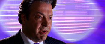 Movie still from “Speed Racer” (2008), directed by Lilly Wachowski – A person wearing a suit and tie; Close Up shot, Over the shoulder angle