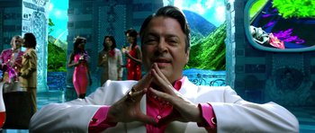 Movie still from “Speed Racer” (2008), directed by Lilly Wachowski – A man in a white and pink suit posing for a picture; Close Up shot, Low angle