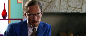 Movie still from “Speed Racer” (2008), directed by Lilly Wachowski – A person wearing a suit and tie; Close Up shot, Over the shoulder angle