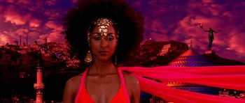 Movie still from “Speed Racer” (2008), directed by Lilly Wachowski – A woman in a red bathing suit with a gold headpiece; Close Up shot, Low angle