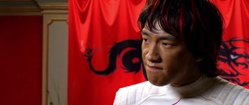 Movie still from “Speed Racer” (2008), directed by Lilly Wachowski – A young man in front of a red dragon flag; Close Up shot, Low angle