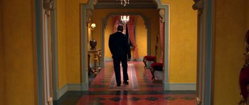 Movie still from “Speed Racer” (2008), directed by Lilly Wachowski – A man in a suit walking down a hall way; Wide shot, High angle